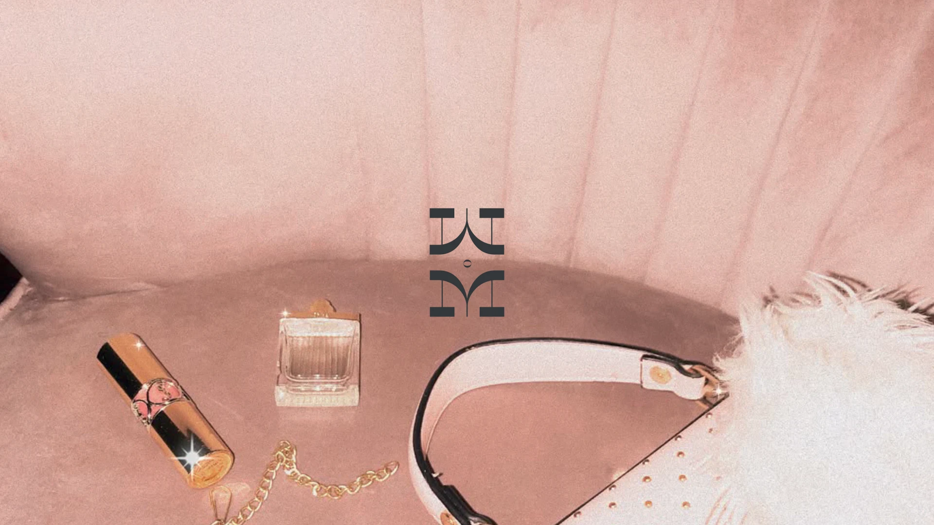 A blush velvet sofa with carefully arranged personal accessories